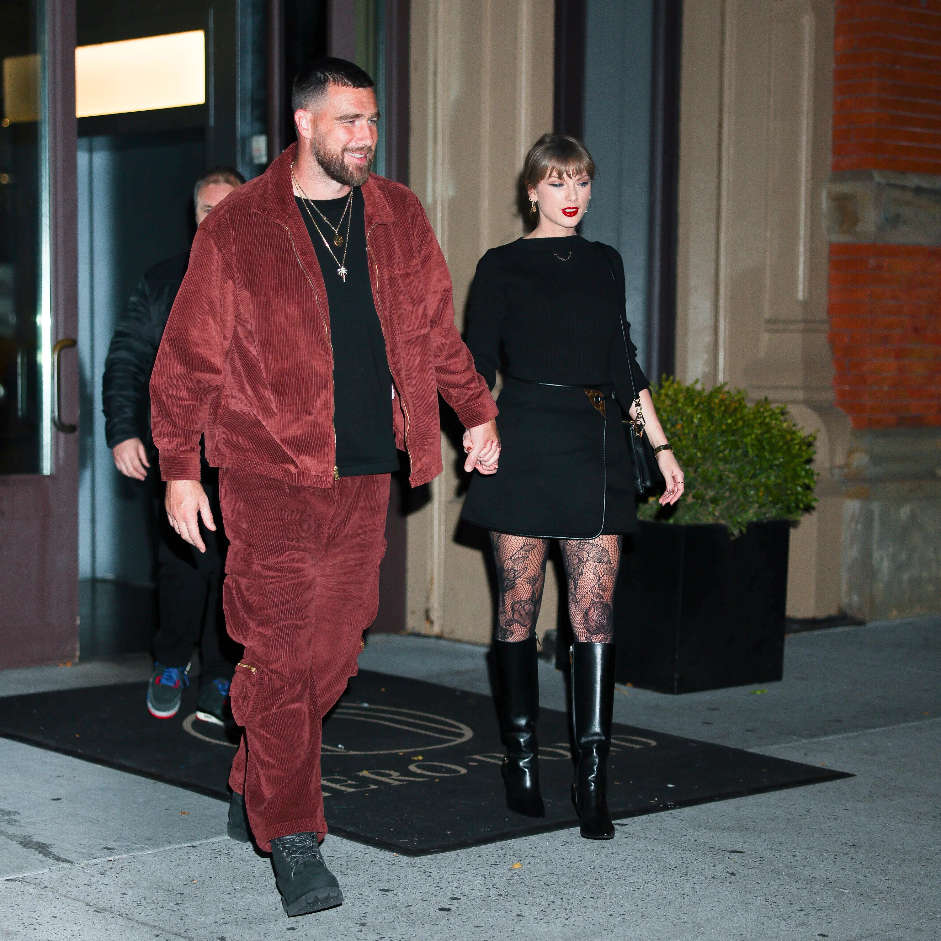 Taylor Swift and Travis Kelce hold hands while walking together in New York City.