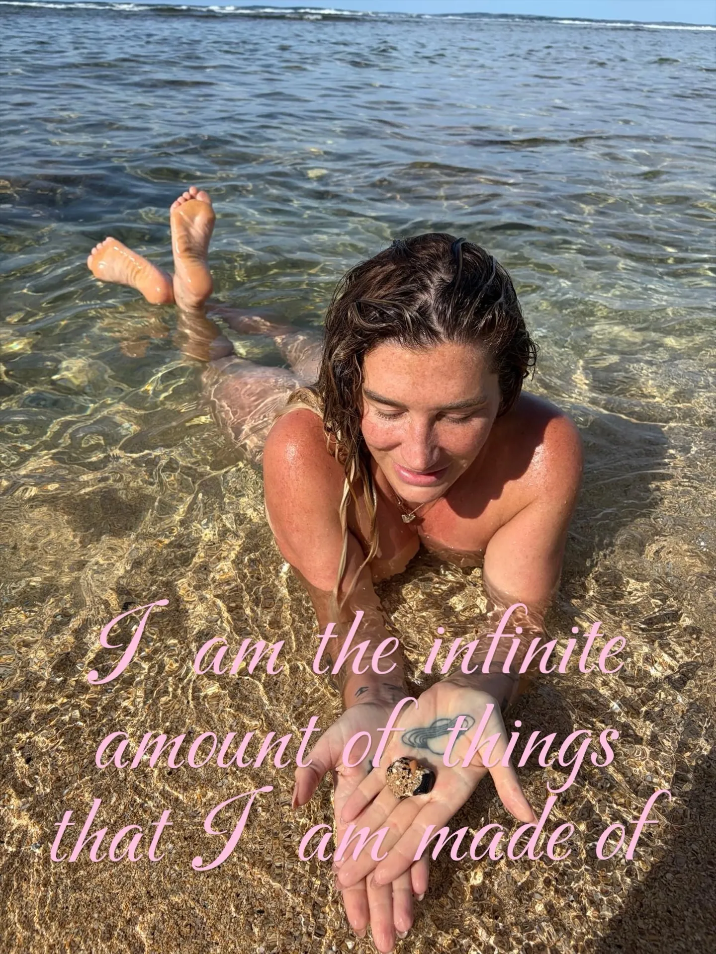 Kesha lies in shallow ocean water, holding a seashell, with text overlaid.