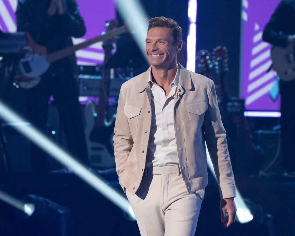 Ryan Seacrest smiling on stage during