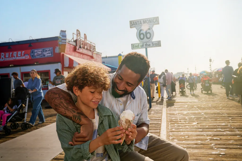 A man and child on the Santa Monica Pier, in front of the Route 66 