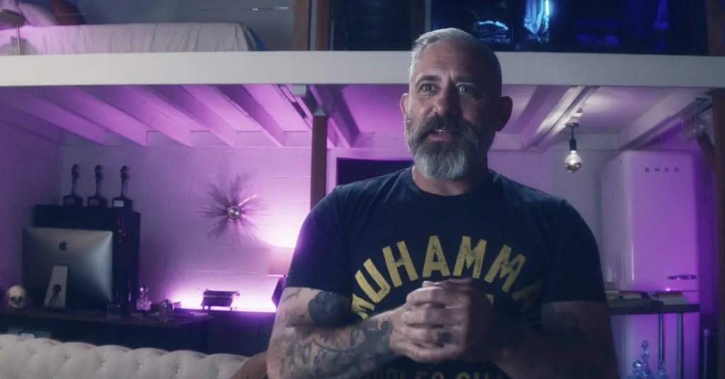 A man with a beard, tattoos, and a 