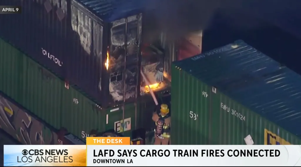 A firefighter battling a blaze in a cargo container on a train in Boyle Heights.
