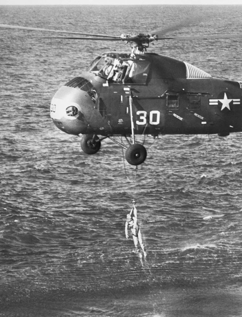 A United States Marine helicopter lifts astronaut Virgil Grissom from the Atlantic Ocean.