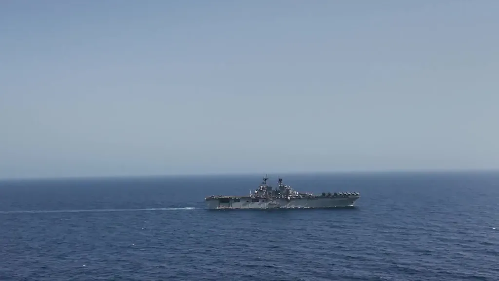 A US Navy vessel moving across the ocean.