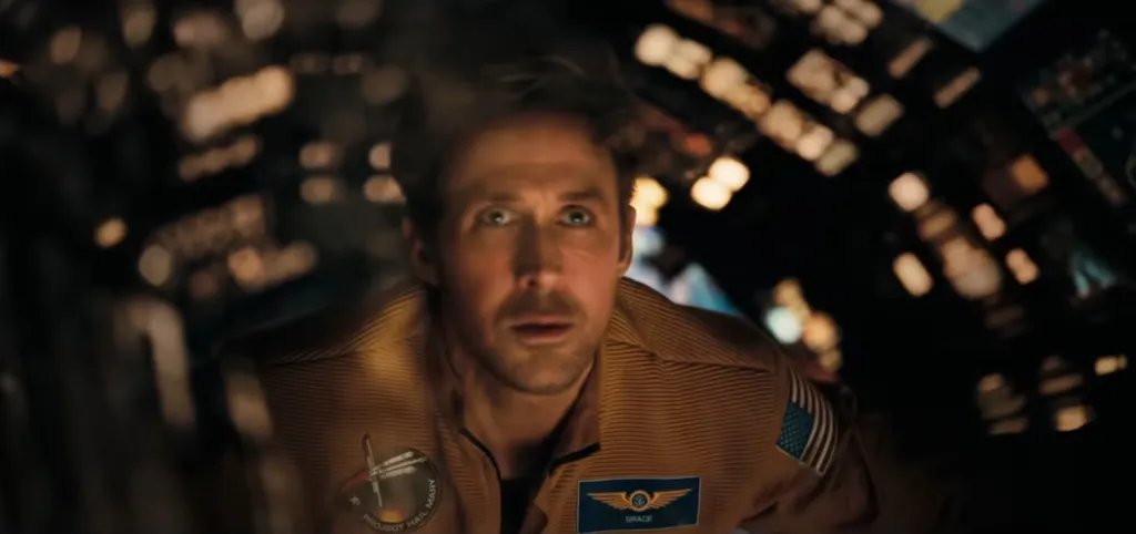 Ryan Gosling as Ryland Grace from Project Hail Mary, wearing a flight suit and floating in a dimly lit spacecraft.