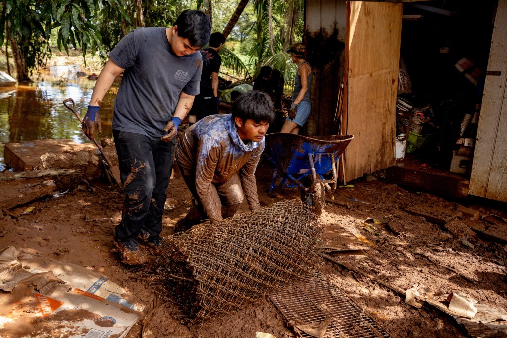 Volunteers clear debris from a house damaged by a flood in Haleiwa, Hawaii.