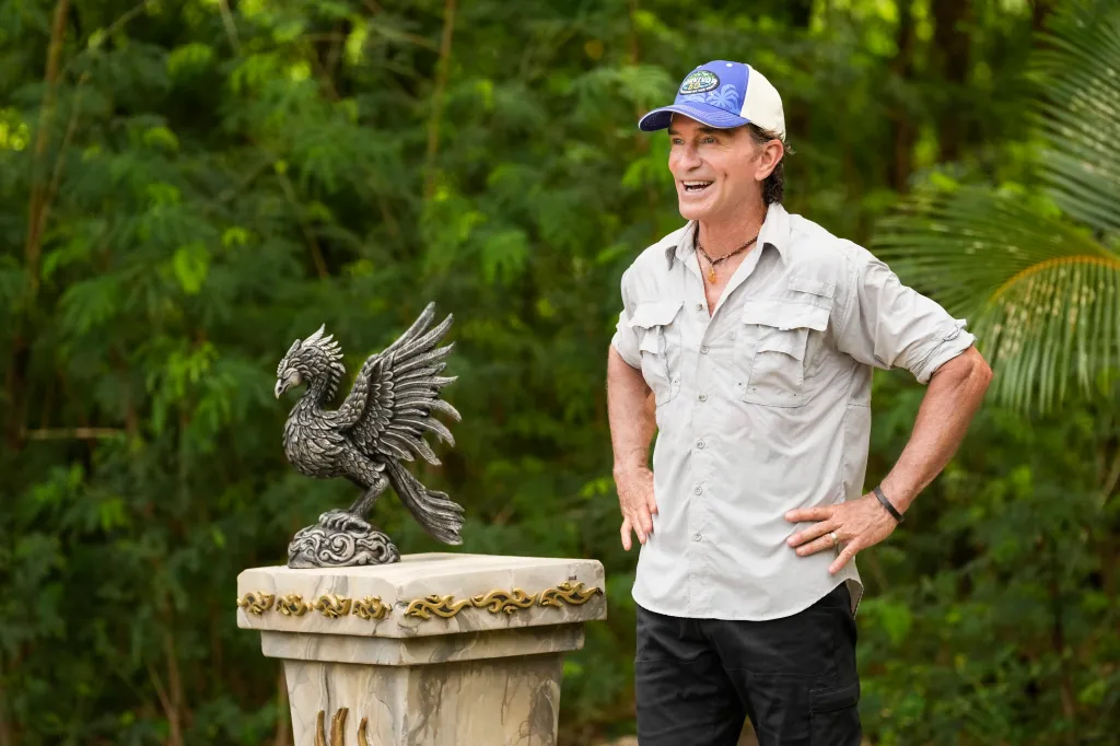 Jeff Probst standing next to a phoenix statue.