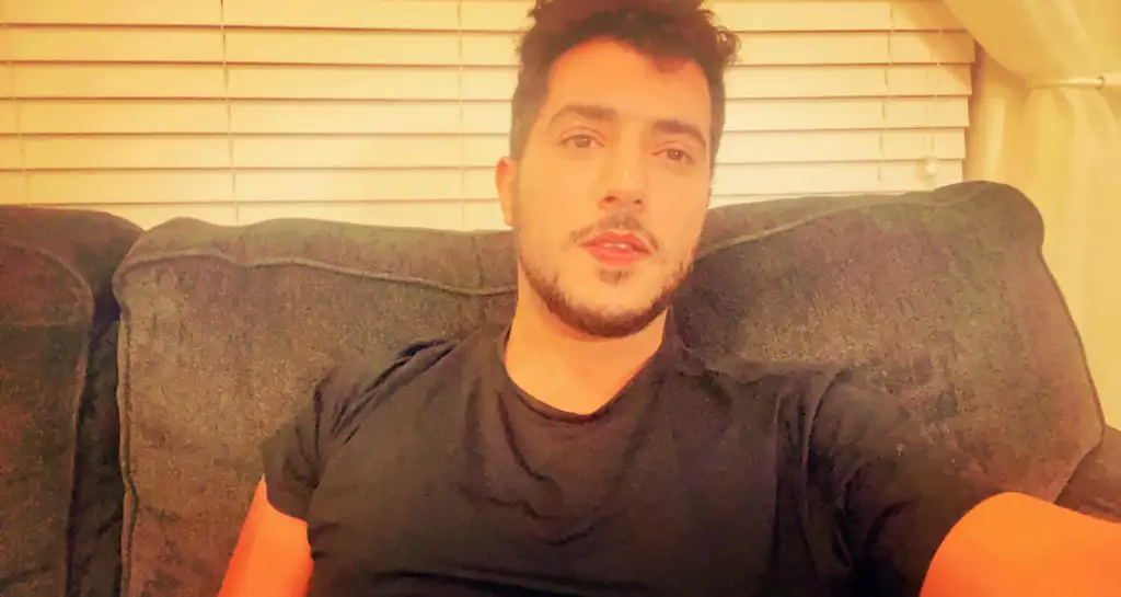 Abdulmalek Anwar sitting on a couch.