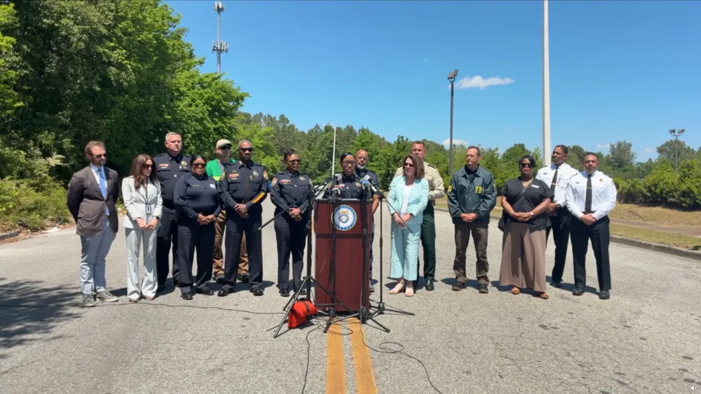 Officials at a press conference regarding human remains discovered in a wooded area.