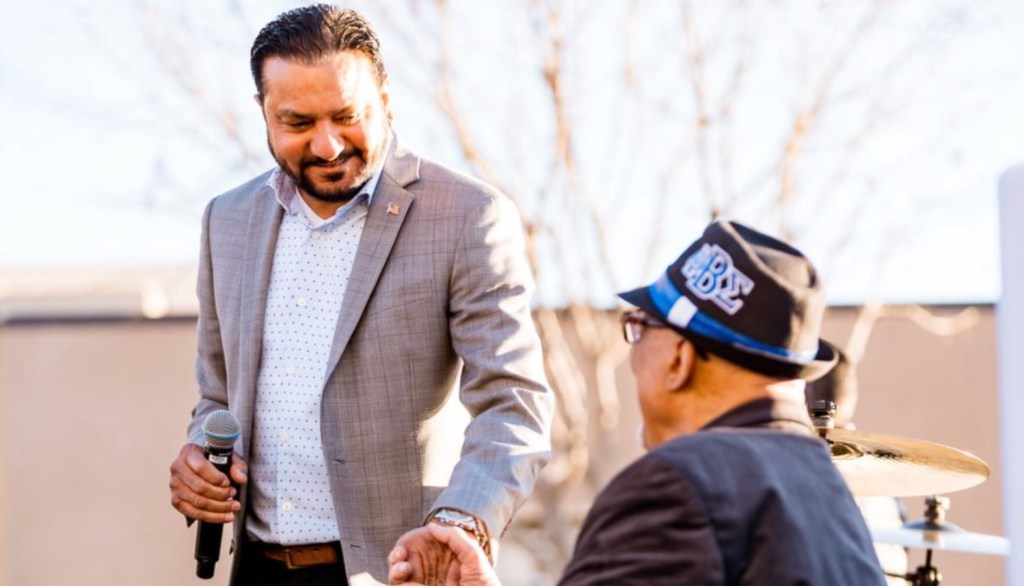 Raj Malhi shaking hands with another person.