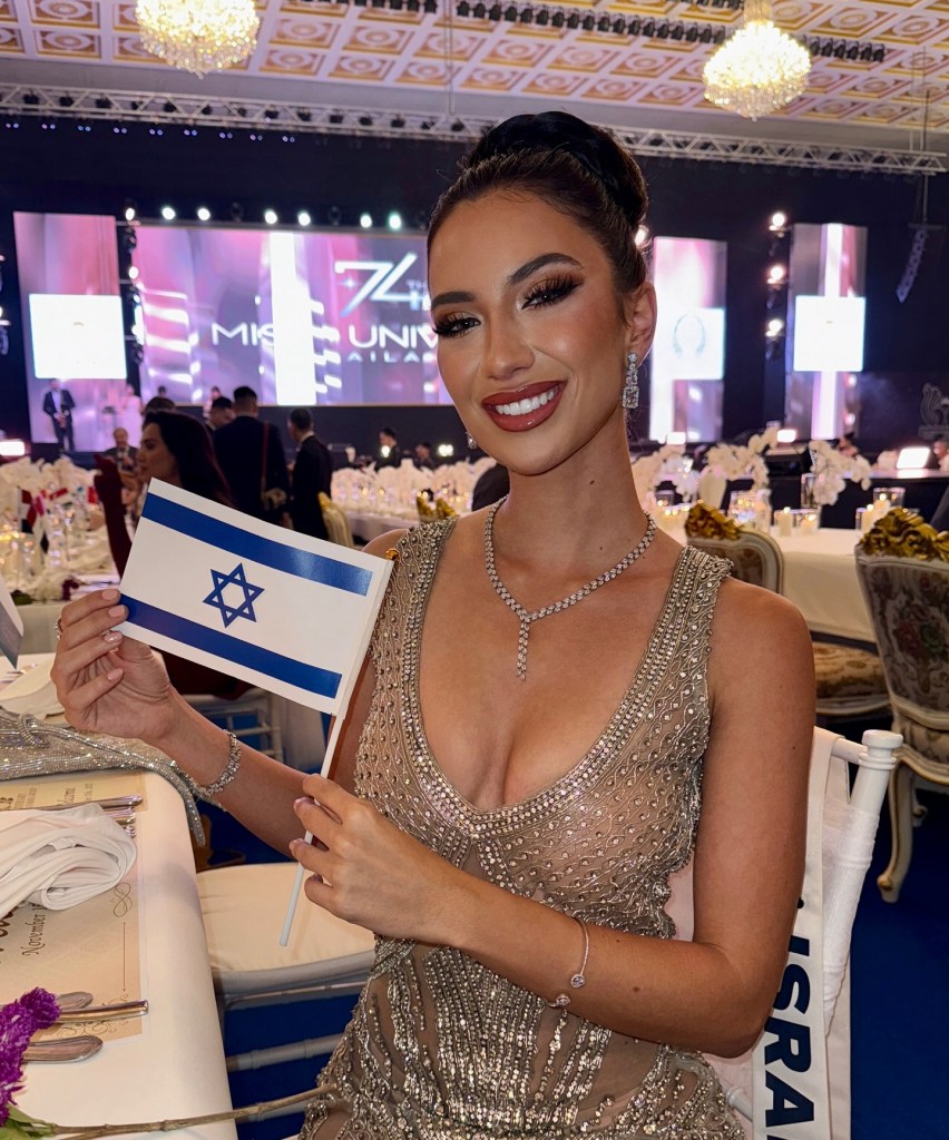 Melanie Shiraz Asor smiling and holding an Israeli flag.