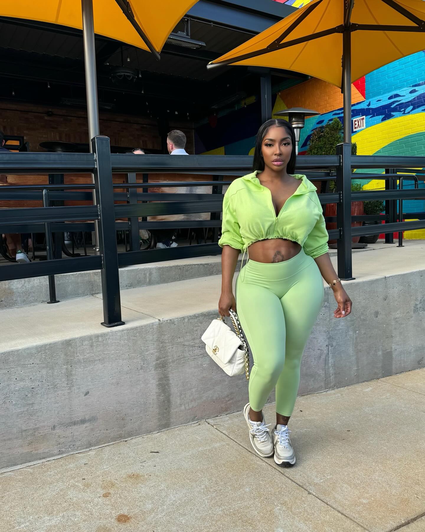 Ayesha Howard posing in a bright green athletic outfit.