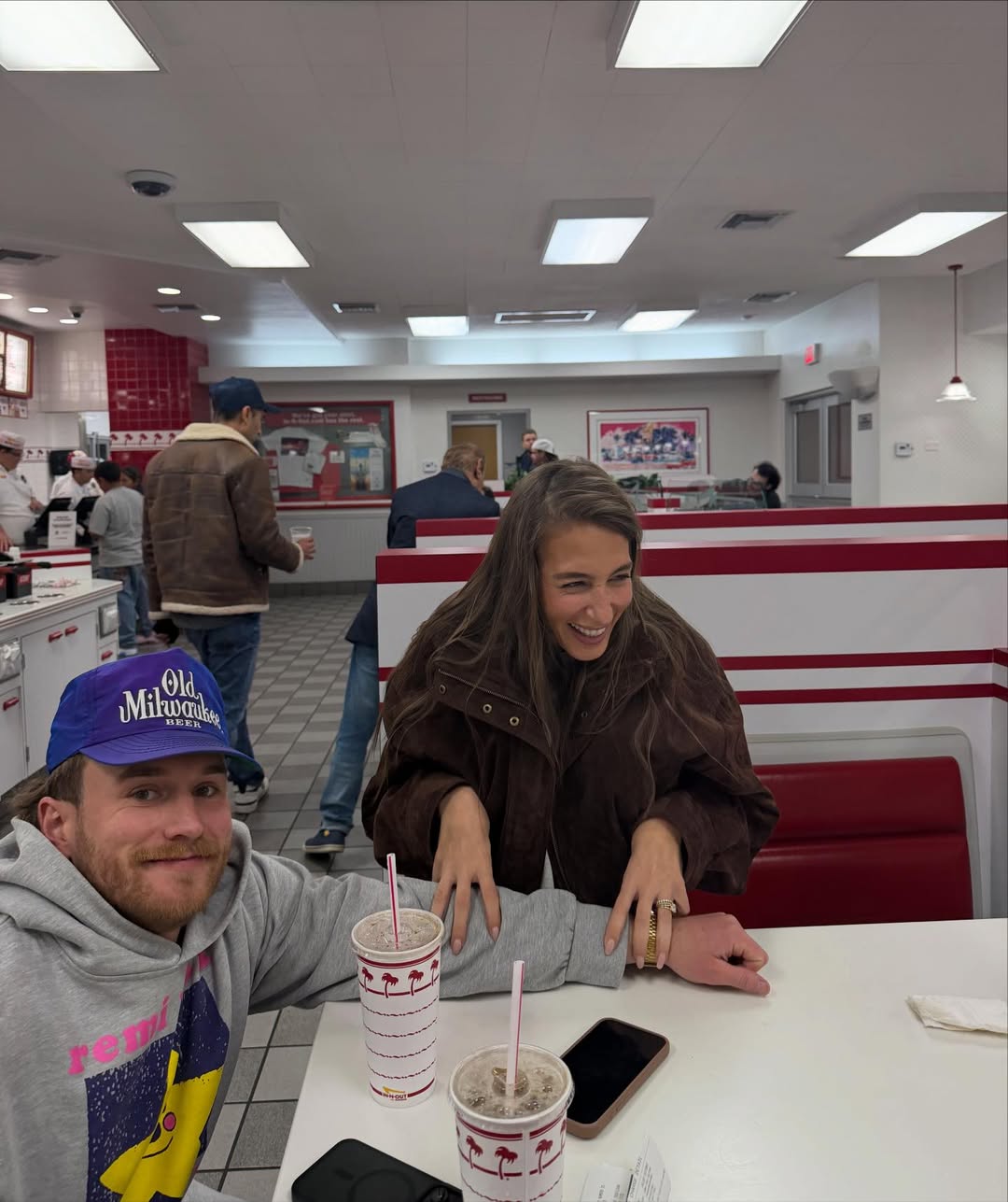 Amanda Batula and West Wilson sitting at a diner table with milkshakes.