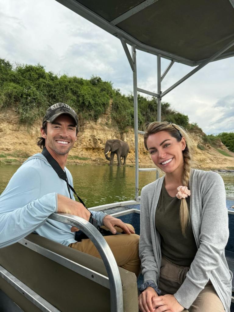 Crystal Harris and James Ward on a boat with an elephant in the background.