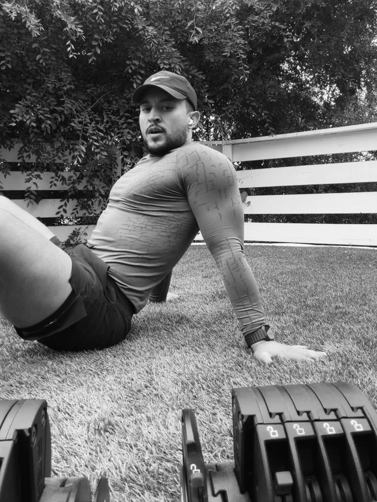 Tahj Mowry exercising outdoors on grass.