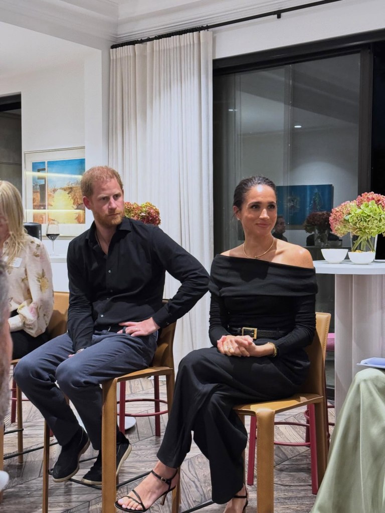 Prince Harry and Meghan Markle sitting in chairs, looking towards the right.