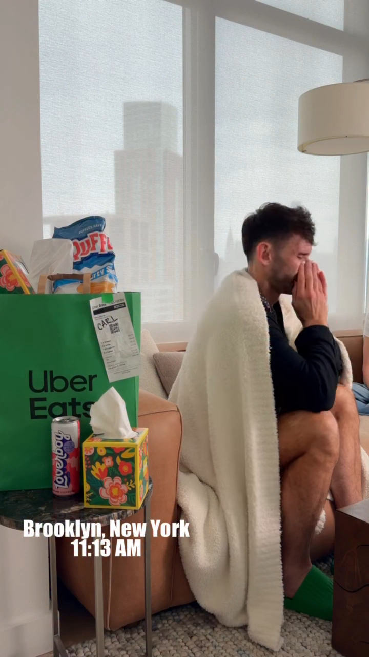 Carl Radke wrapped in a blanket, with an Uber Eats bag and a can of Loverboy nearby.