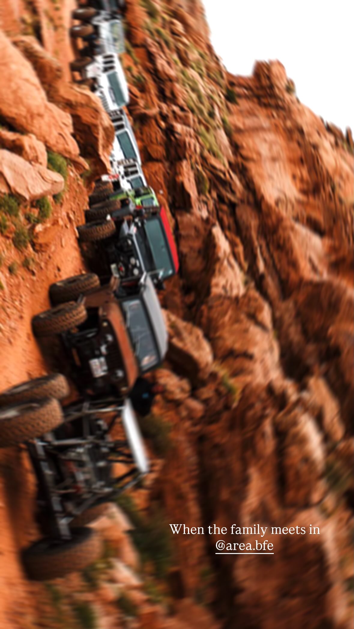 Vehicles off-roading on a steep dirt path.