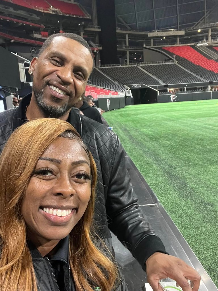 Tiffany Henyard and Kamal Woods smiling in a stadium.