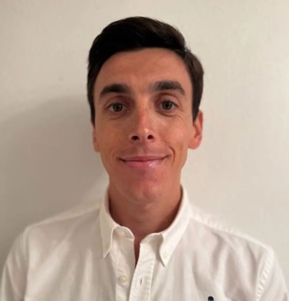 A young man with dark hair wearing a white shirt.