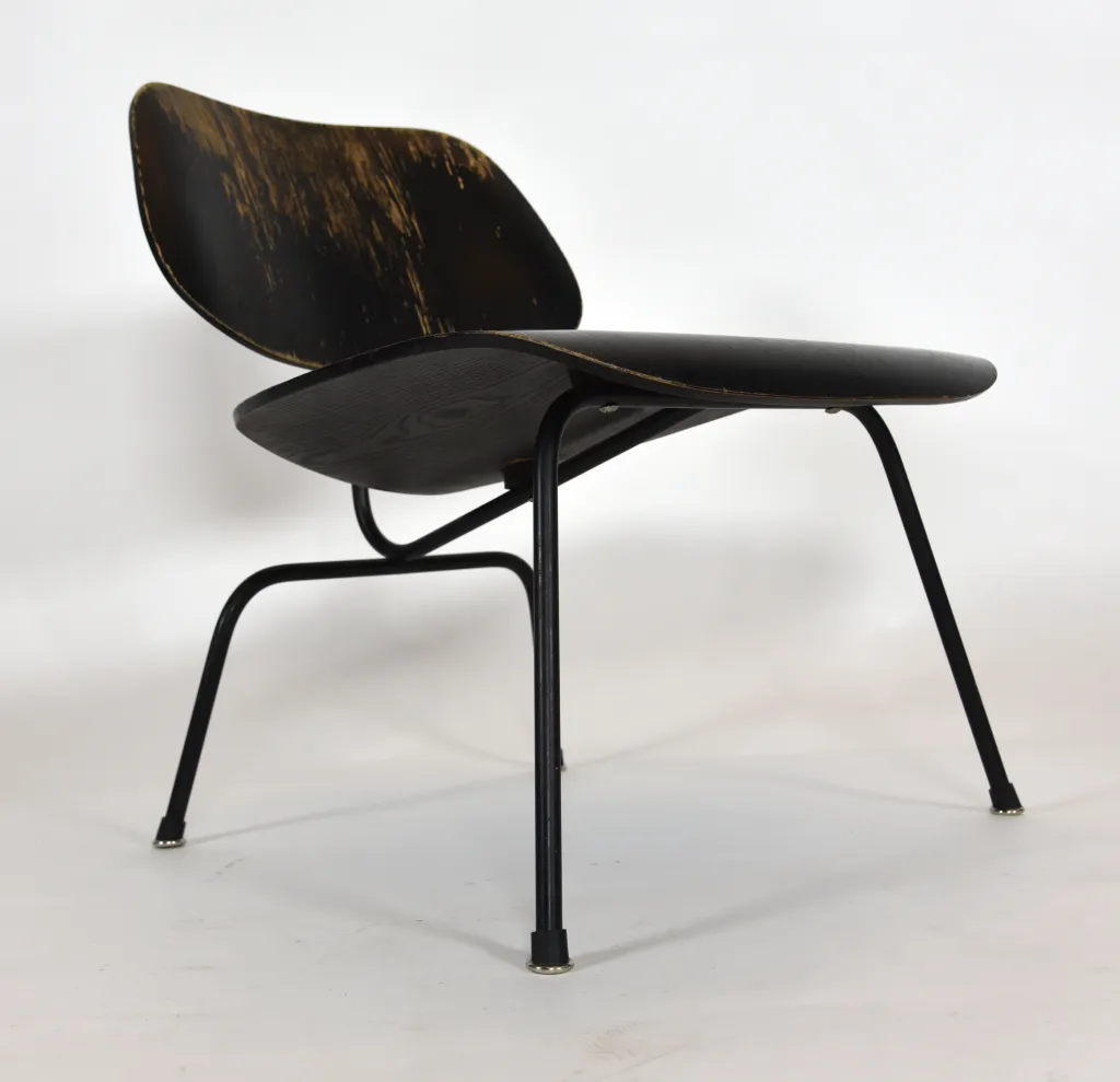 Black wooden chair with a subtly distressed surface and thin black legs on a white background.