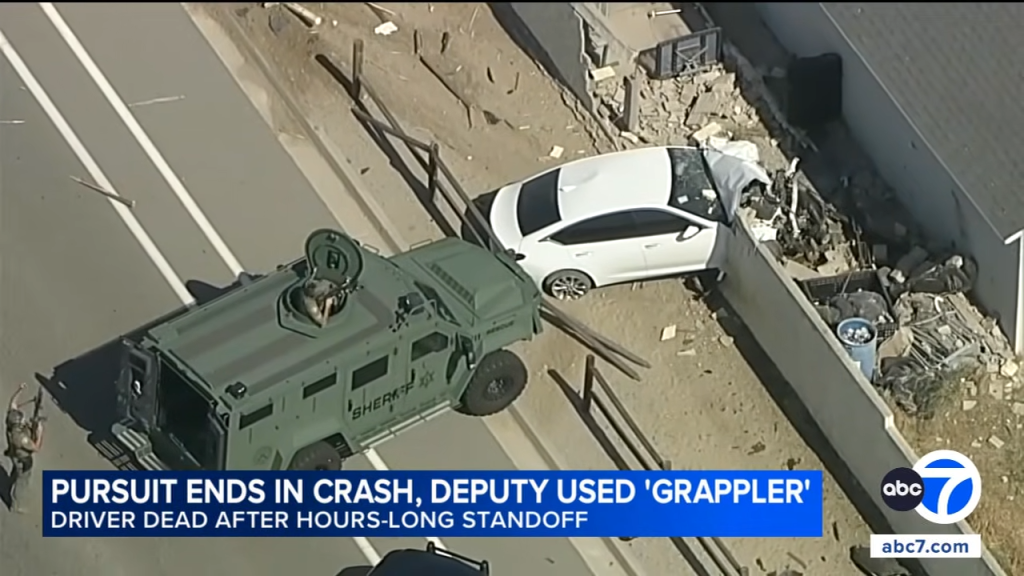 Aerial view of an armored police vehicle and a crashed white car against a wall, with text overlays about a pursuit ending in a crash.