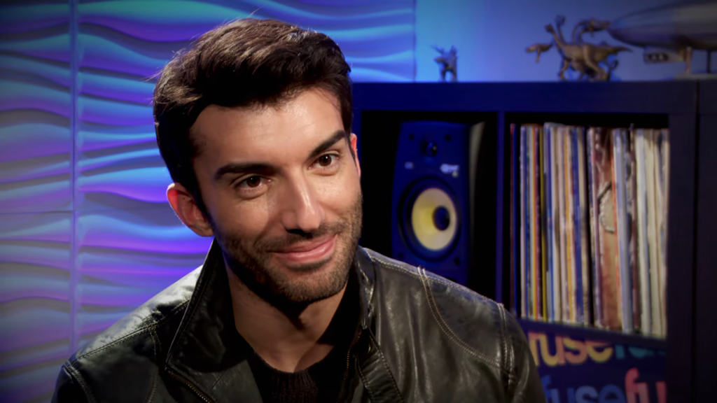 Justin Baldoni in a black leather jacket.