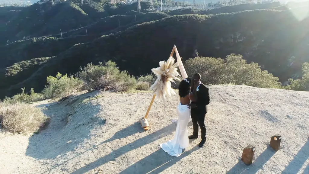 Kiara Brokenbrough and Joel Brokenbrough embrace at their wedding ceremony on a mountain top.