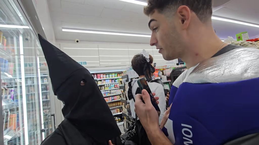 Ismael, wearing a black hood, is confronted by a man inside a South Korea convenience store.