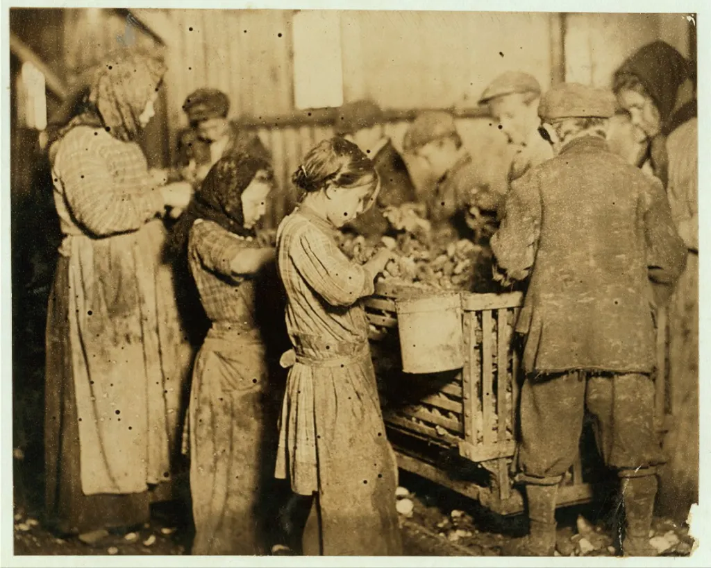 Children and adults shucking oysters at the Varn & Platt Canning Company.