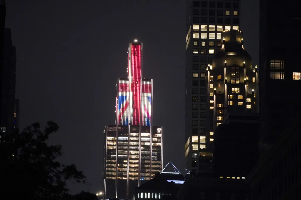Building illuminated with the Union Jack flag at night.