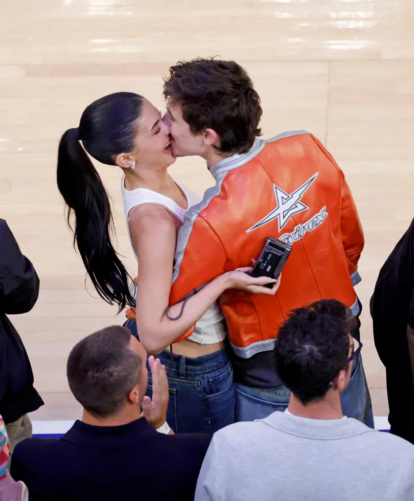 Kylie Jenner and Timothee Chalamet share a kiss courtside during an NBA playoff game.