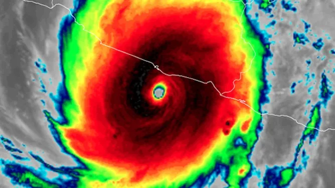 Infrared satellite image showing a massive, red hurricane over a landmass with a visible eye.