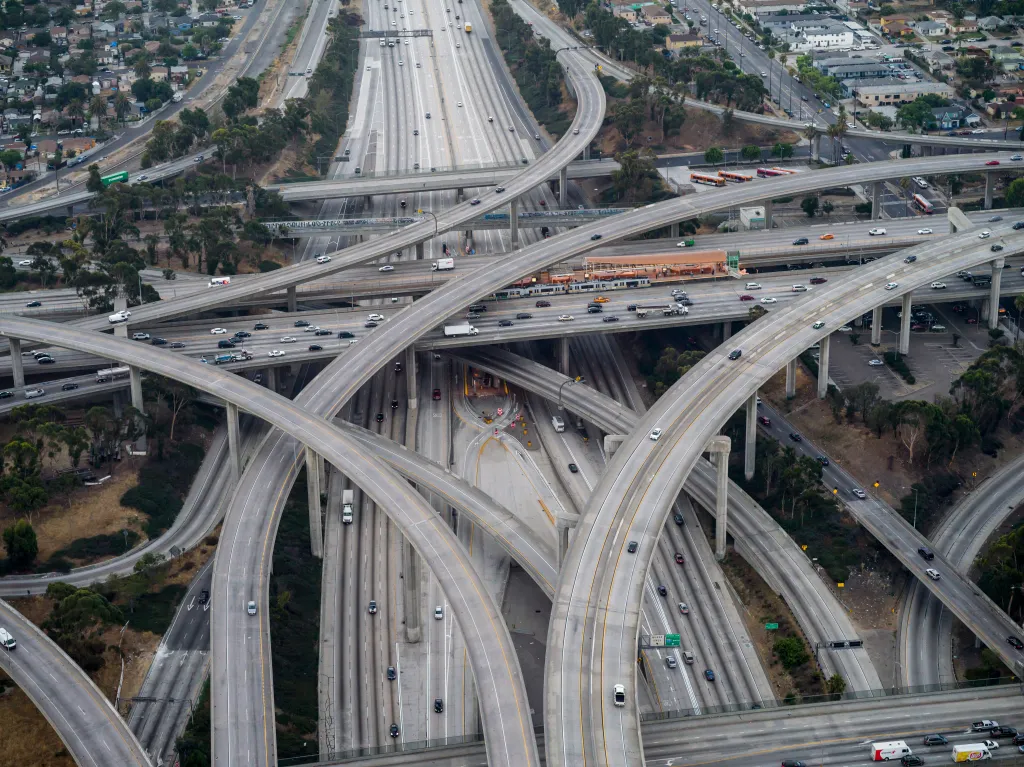 Aerial view of the Interstate 110 and 105 interchange in Los Angeles, California, with multiple layers of highways and commuter traffic.