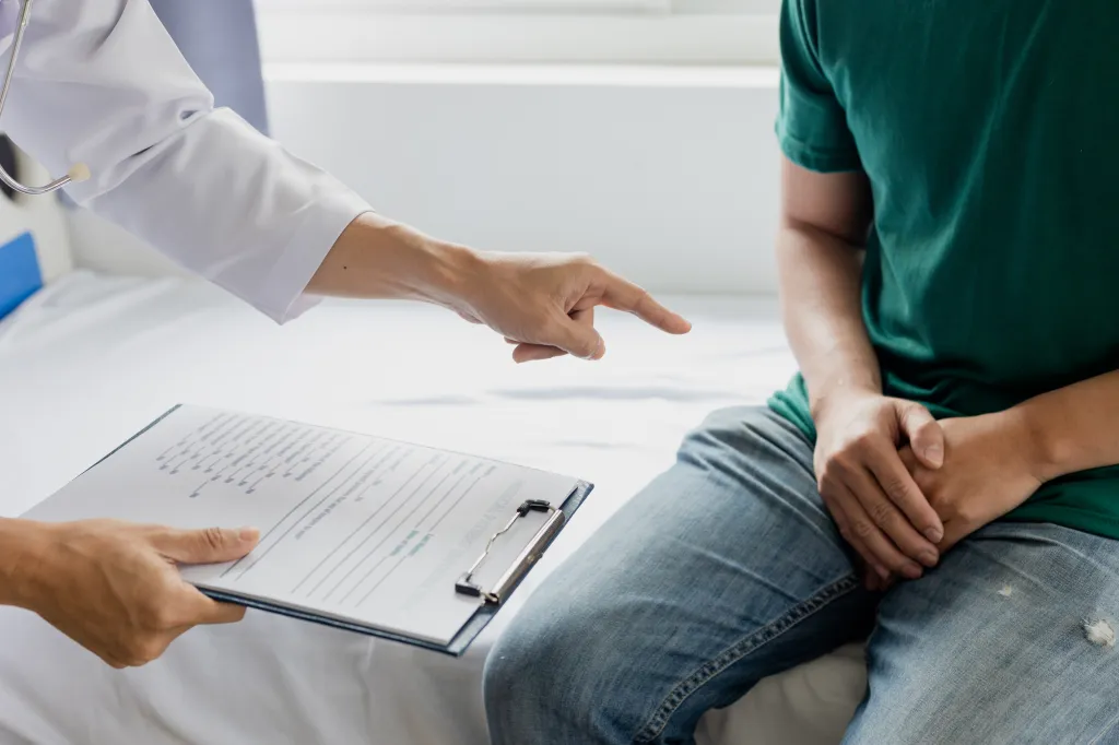 Doctor diagnosing man with STI. 