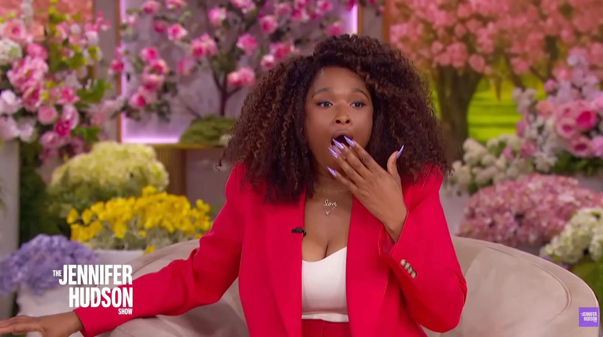 Jennifer Hudson looking surprised with her hand over her mouth.