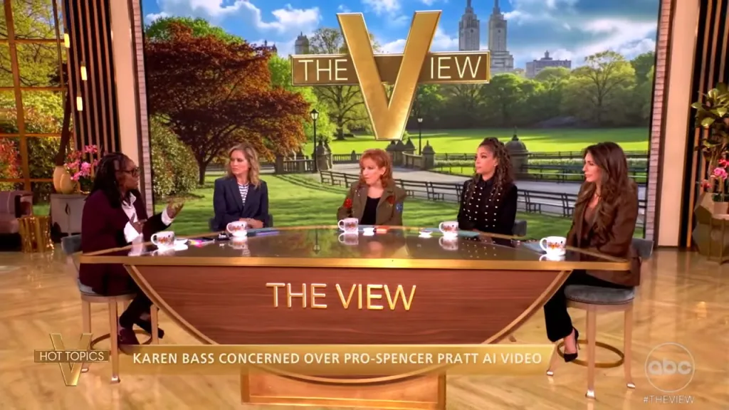 Five female panelists sit around a curved desk with 