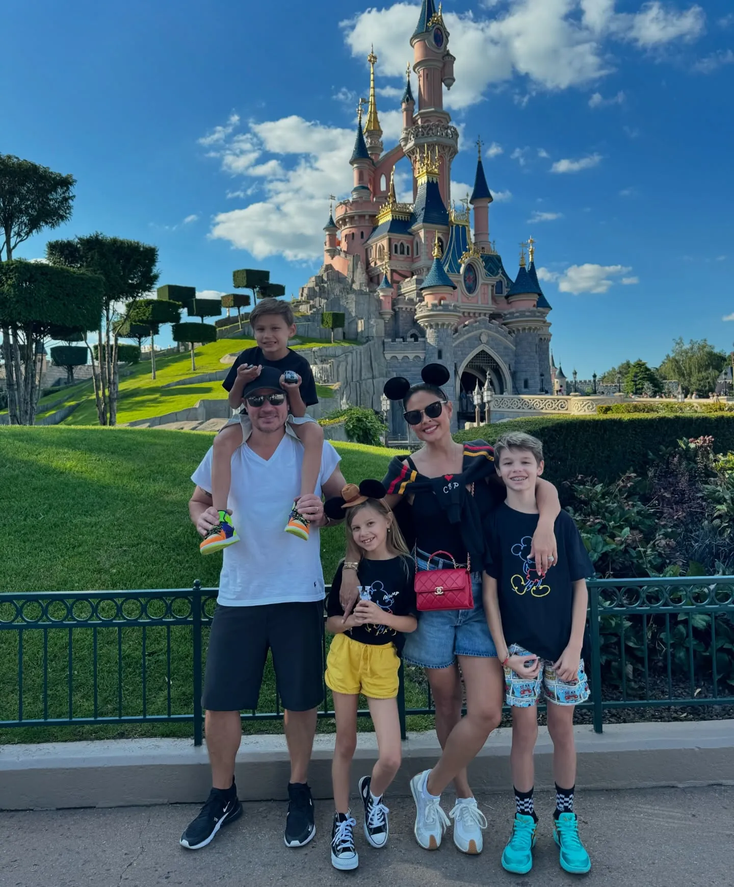 Nick and Vanessa Lachey and their three children pose in front of a Disney castle.