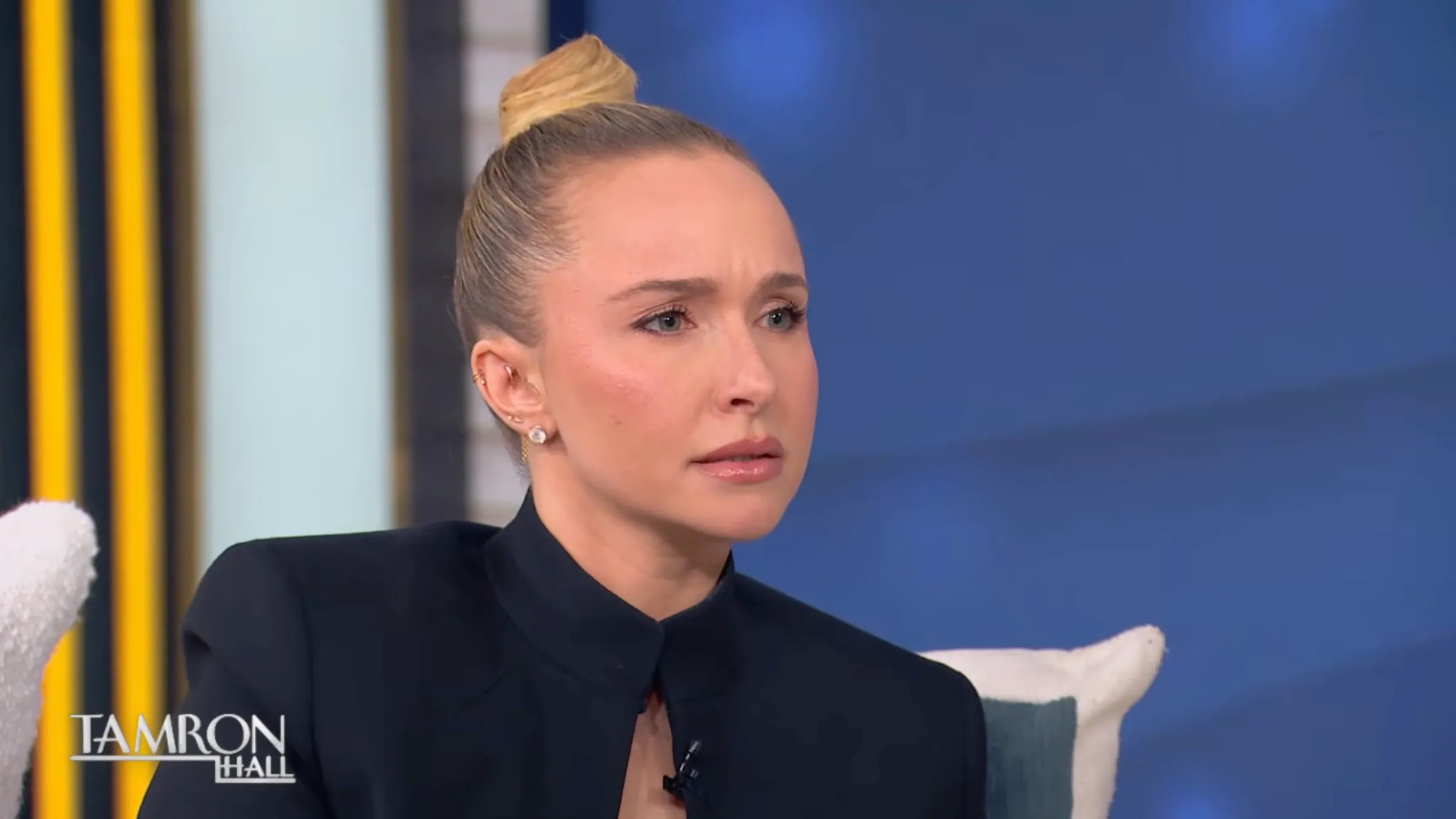 Actress Hayden Panettiere with blonde hair in a bun, wearing a black shirt, on the Tamron Hall show.