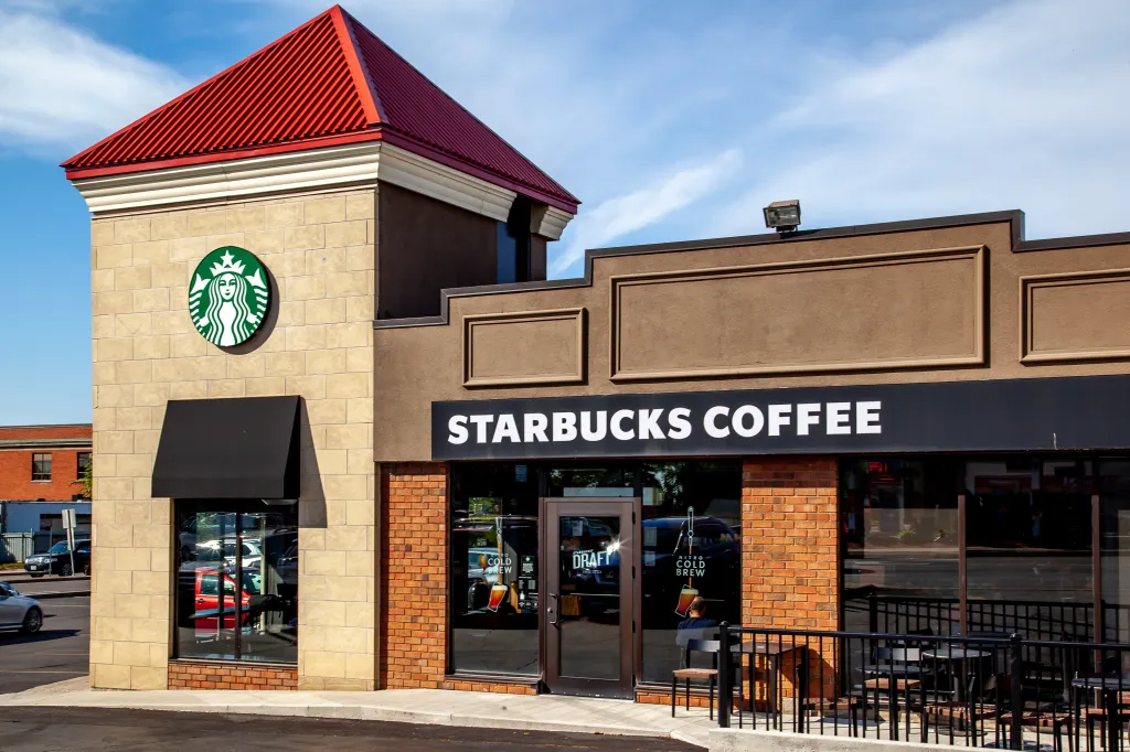 Exterior of a Starbucks coffee store with a red roof and the Starbucks logo on the side in St. Catharines, Ontario.