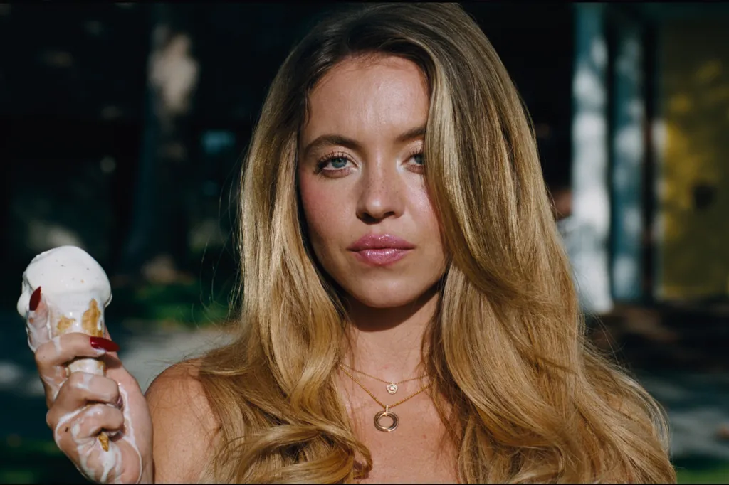 A young woman with long blonde hair and bright blue eyes holds a melting ice cream cone.