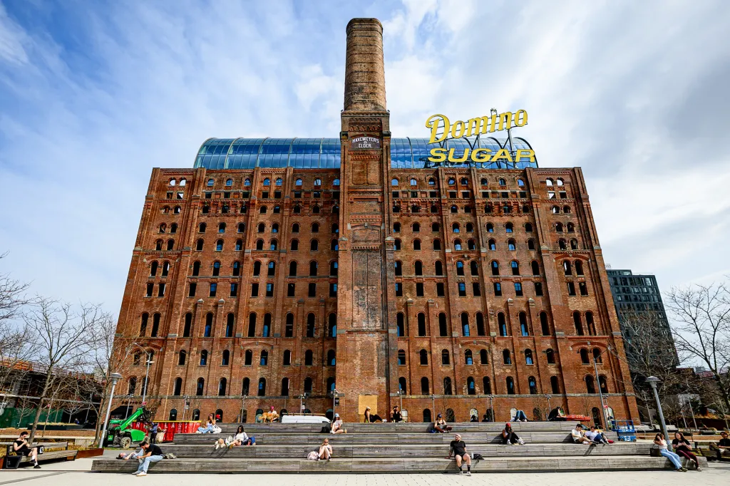 Domino Sugar Refinery building with a tall brick chimney and 
