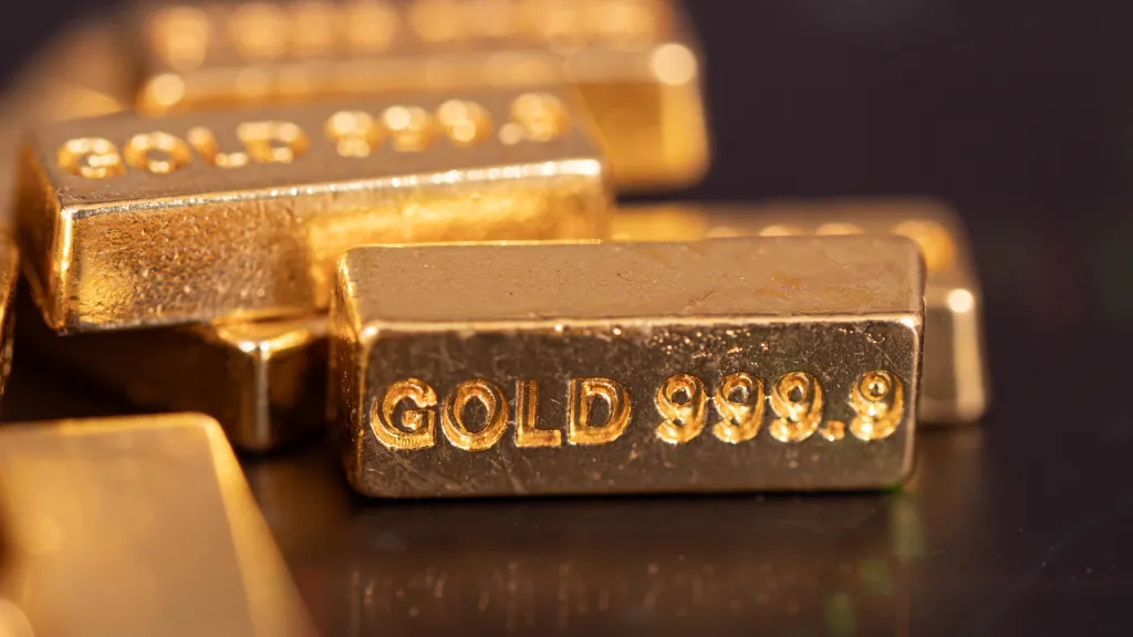 Close-up of several gold bars, with one in focus displaying 