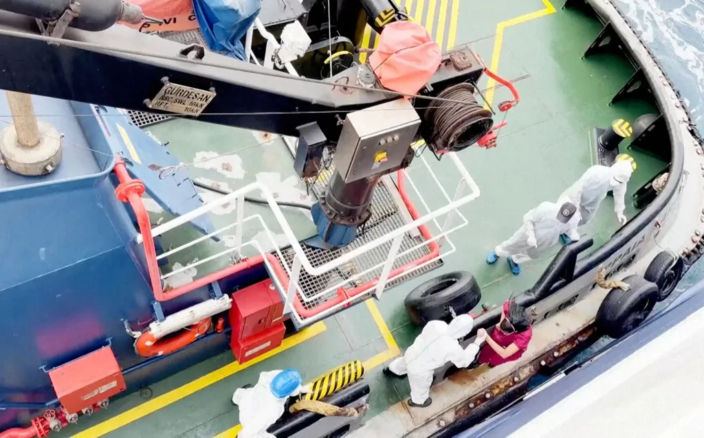 Health workers in protective suits getting off a Dutch-flagged cruise ship suspected of a hantavirus outbreak off Cape Verde.