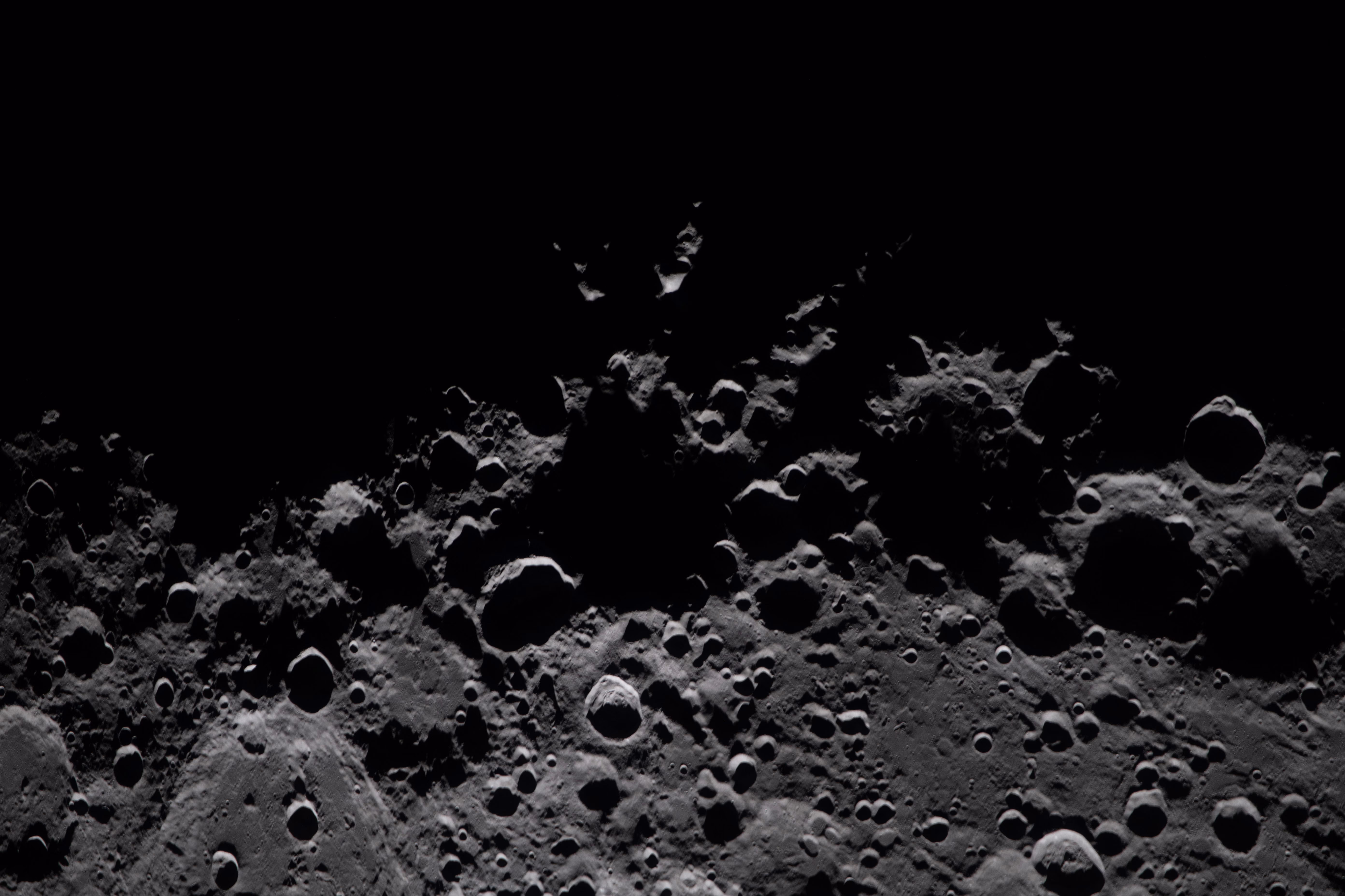 A close view of shadowy craters on the lunar surface