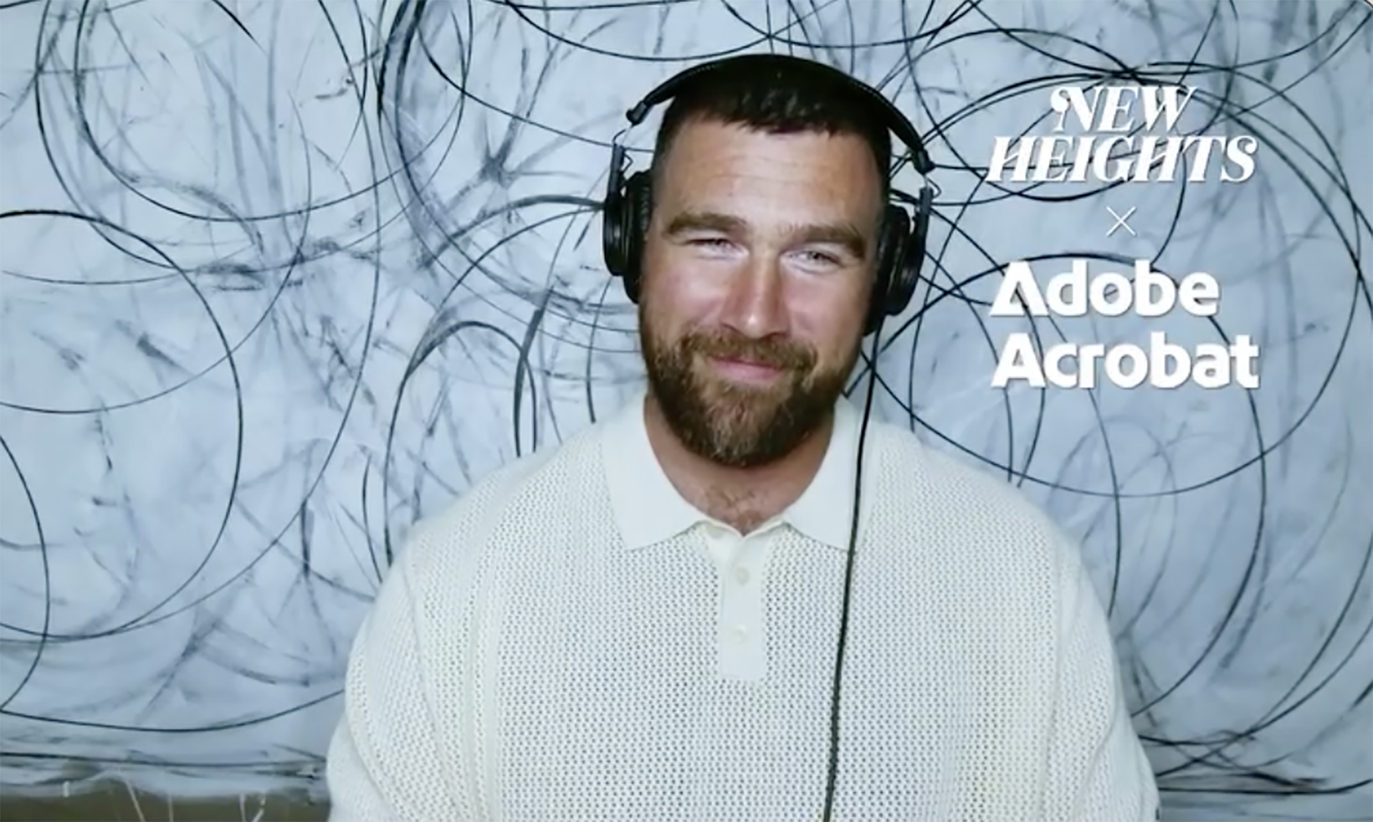 Travis Kelce wearing headphones on the New Heights podcast.