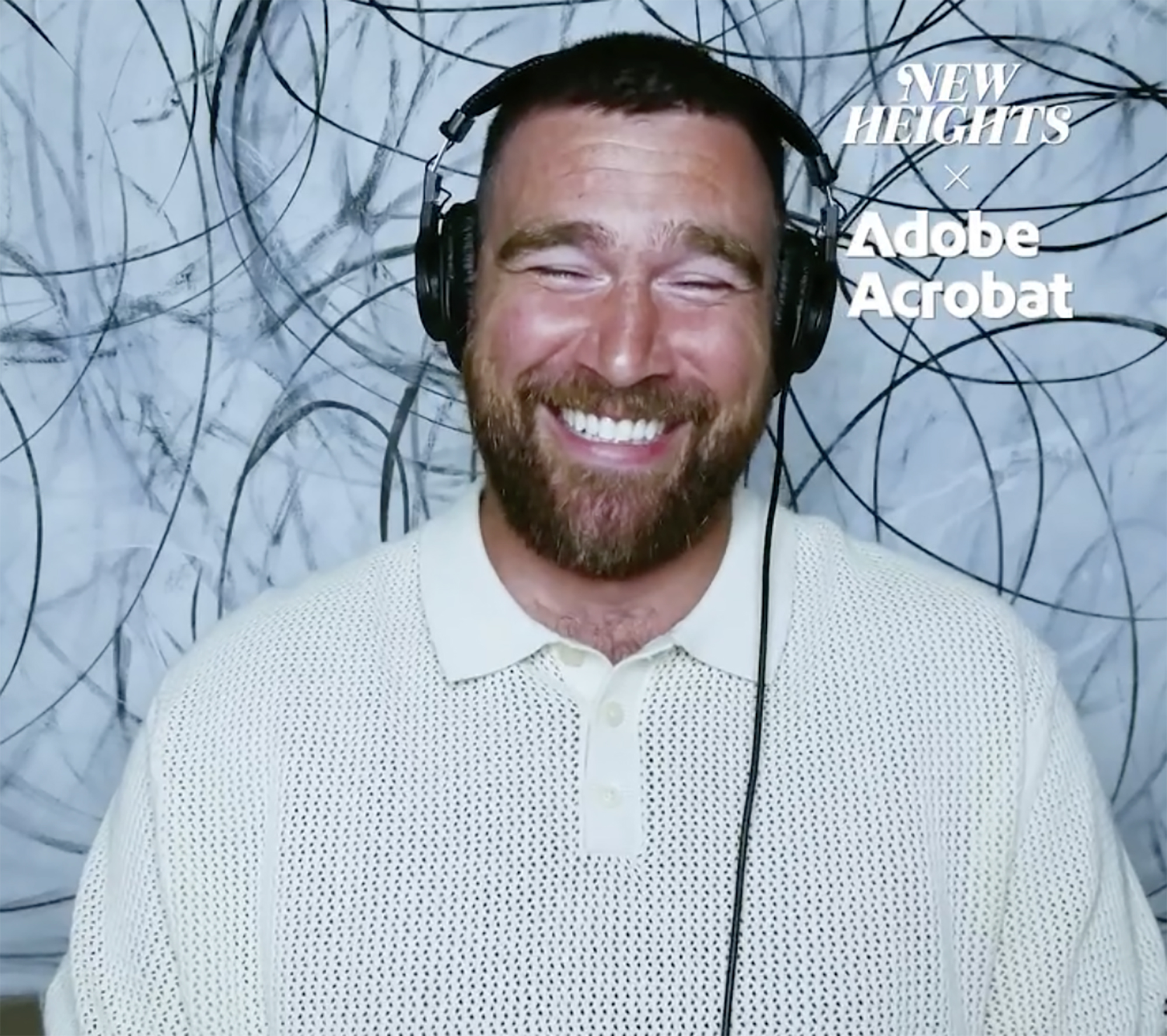 Travis Kelce smiling with his eyes closed while wearing headphones.