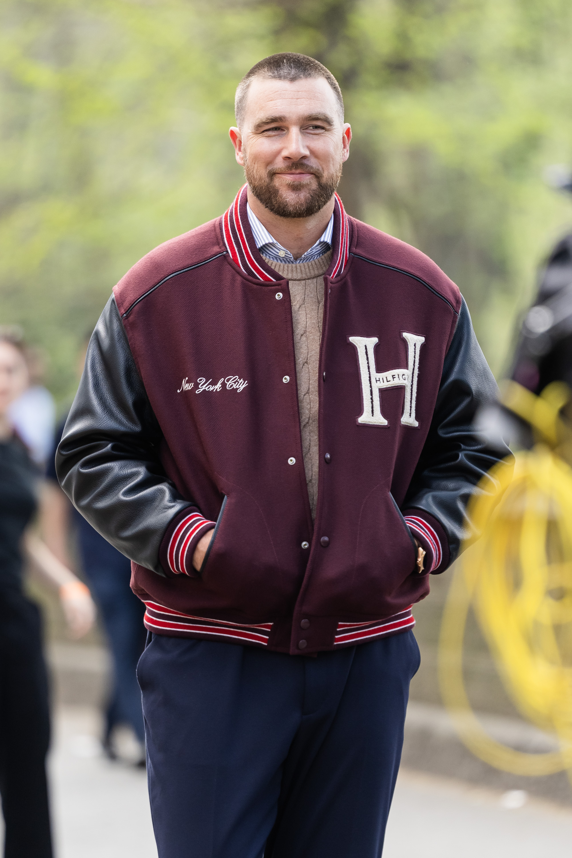 Travis Kelce wearing a Tommy Hilfiger letterman jacket in New York City.