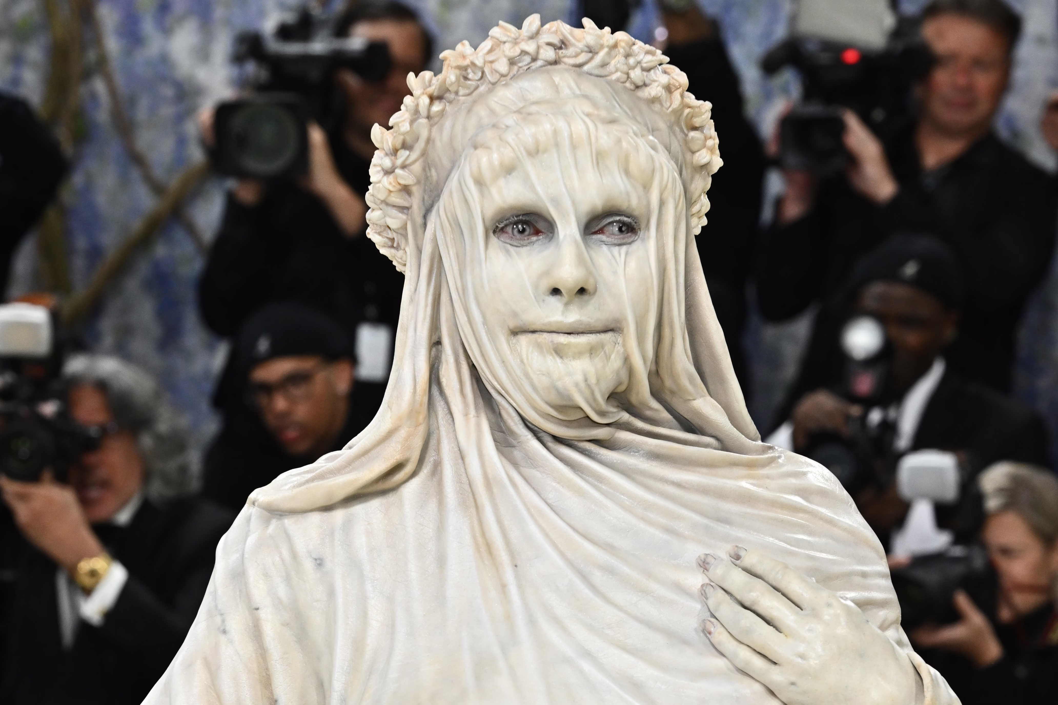 Heidi Klum arrives at the Met Gala, wearing a costume that makes her look like a carved marble statue with a veil and gown.