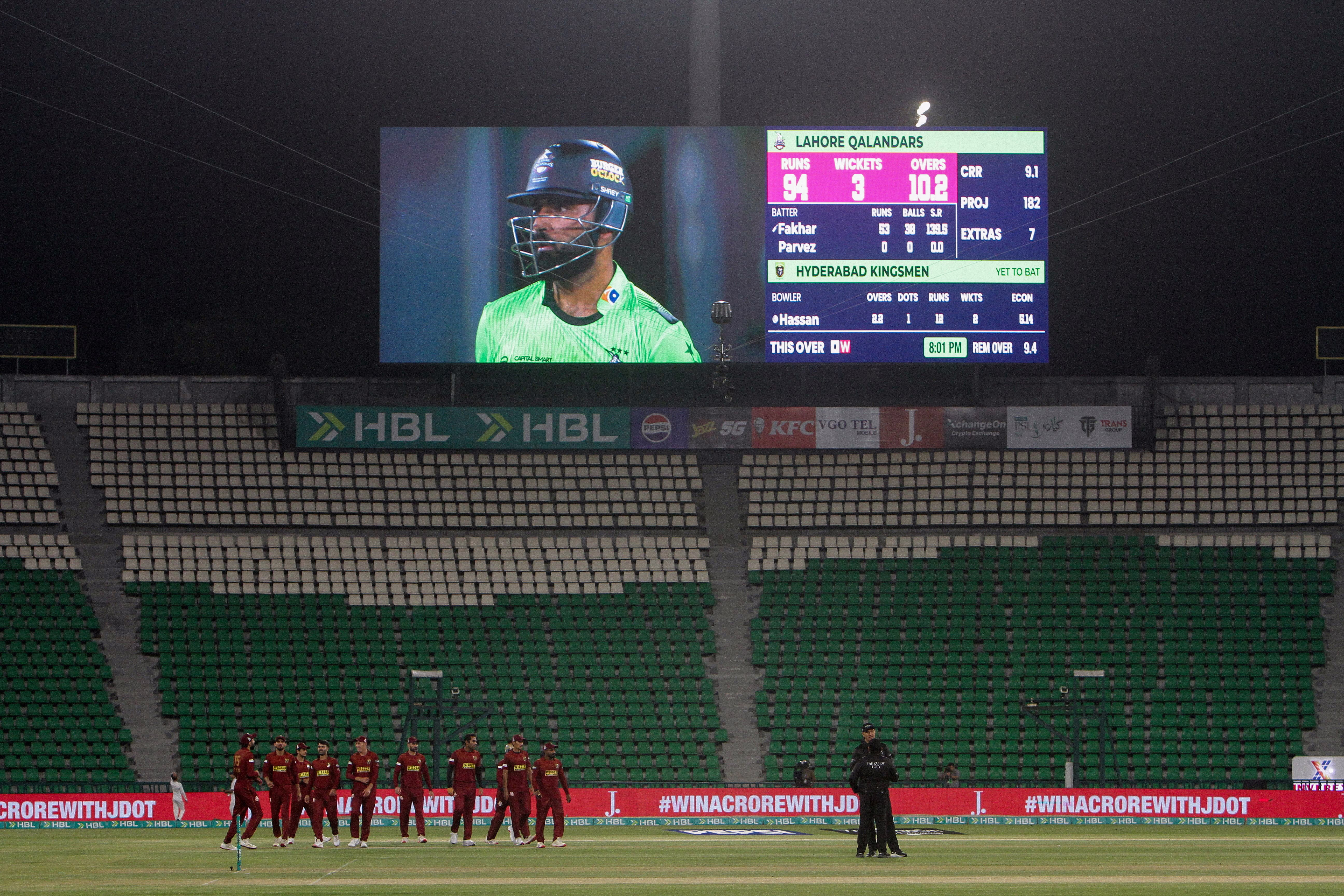 A nighttime cricket match in a deserted stadium